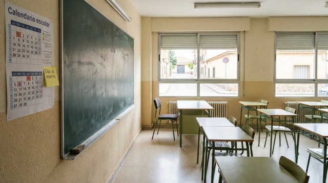 aula vacía con pizarrón y calendario escolar pegado en la pared, título visible 'Calendario escolar' y una nota adhesiva que dice 'Días de reserva'
