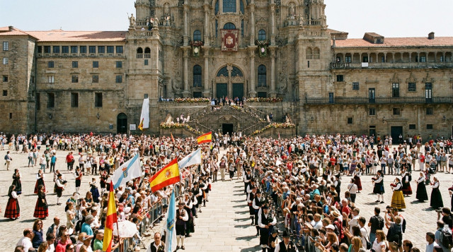 procesión y plaza del Obradoiro en Santiago de Compostela con peregrinos y banderas en un día soleado, foco en la catedral y celebraciones del 25 de julio