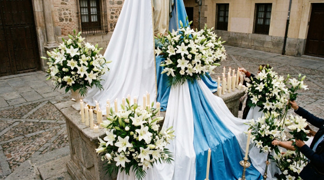 vista cenital de un altar urbano decorado para la Inmaculada con mantos blancos y azules, ramos de azucenas y velas encendidas