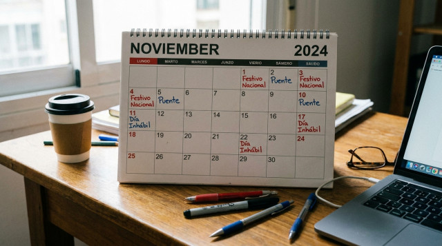 calendario de noviembre sobre una mesa de trabajo con anotaciones de dias laborales y festivos