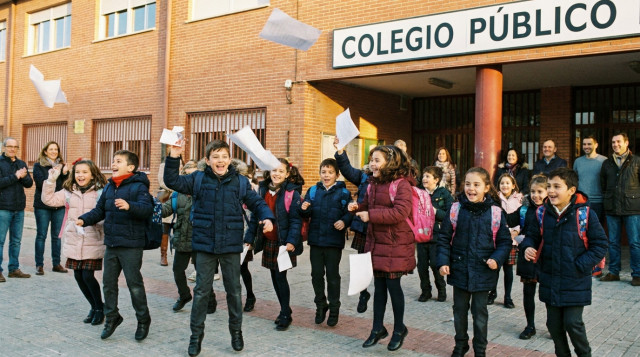 Alumnos saliendo del colegio con mochilas celebrando el inicio del descanso escolar de Navidad