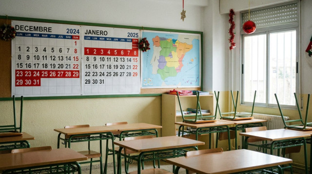 Aula escolar vacía con un calendario de pared que muestra los días festivos de Navidad marcados en rojo