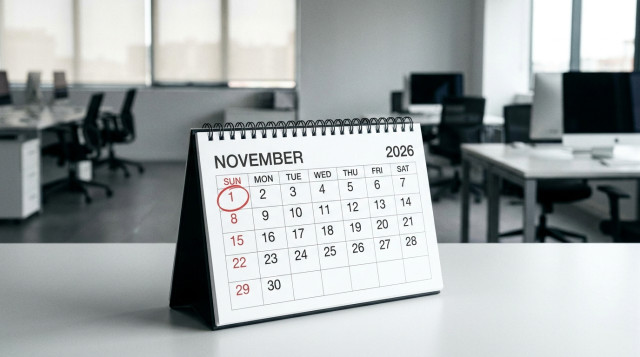 calendario de mesa abierto en el mes de noviembre con el día 1 de noviembre marcado en domingo y oficinas de fondo