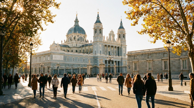 Vista de la Catedral de la Almudena de Madrid durante una mañana soleada de otoño con ciudadanos paseando