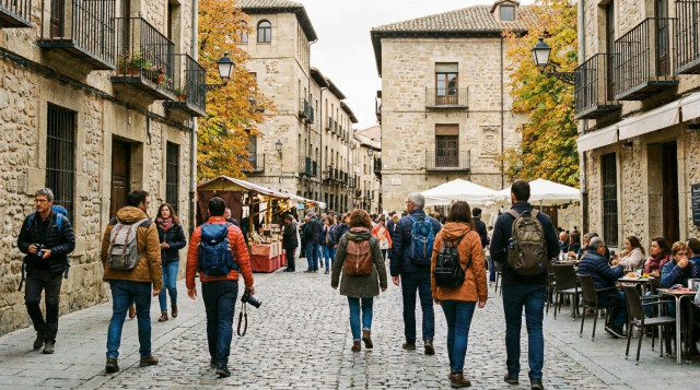 viajeros caminando por el centro histórico de una ciudad española durante el puente del Pilar en otoño
