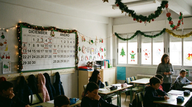 aula de un colegio decorada con adornos para las vacaciones de Navidad en los colegios y un calendario escolar en la pared