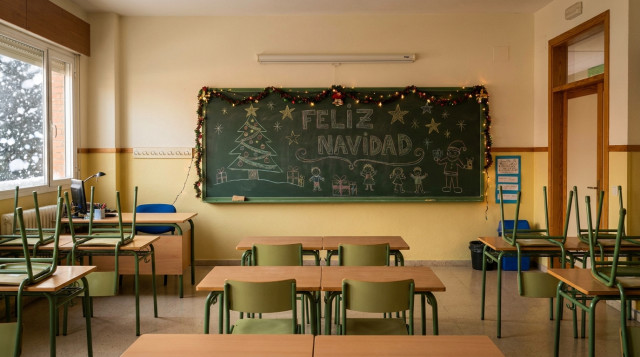 aula de un colegio español vacía en diciembre con adornos navideños en la pizarra, simbolizando las vacaciones escolares de Navidad