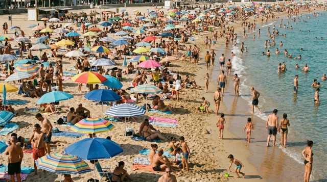 Una playa española con sombrillas y turistas disfrutando del sol durante el festivo del 15 de agosto de 2026