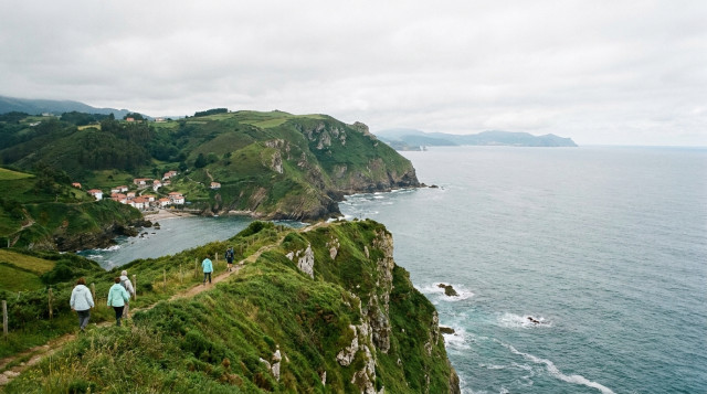 Paisaje costero de Asturias con acantilados verdes y el mar Cantábrico bajo un cielo templado, representando el turismo de refugio climático
