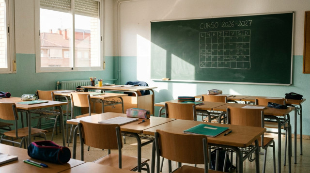 Aulas de un colegio en España preparadas para el inicio del curso escolar con pupitres y pizarra al fondo