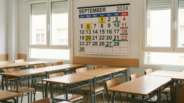 Aula escolar luminosa con pupitres ordenados y un calendario de septiembre visible en el fondo