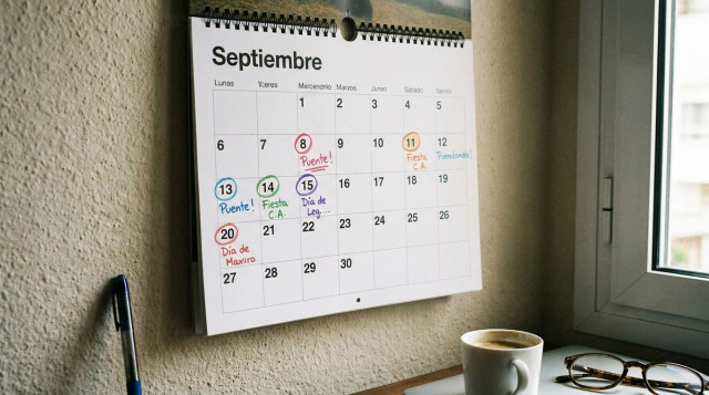 Calendario de pared abierto en el mes de septiembre con anotaciones y fechas destacadas de festivos autonómicos