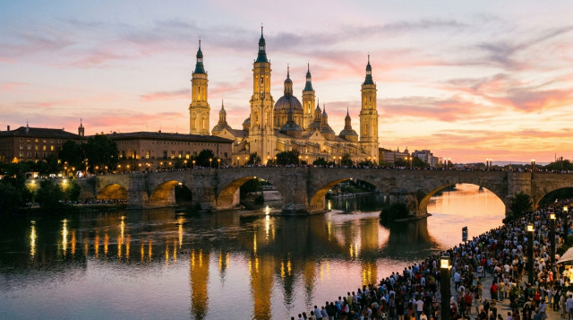 Vista panorámica de la Basílica del Pilar en Zaragoza iluminada al atardecer durante el Puente del Pilar